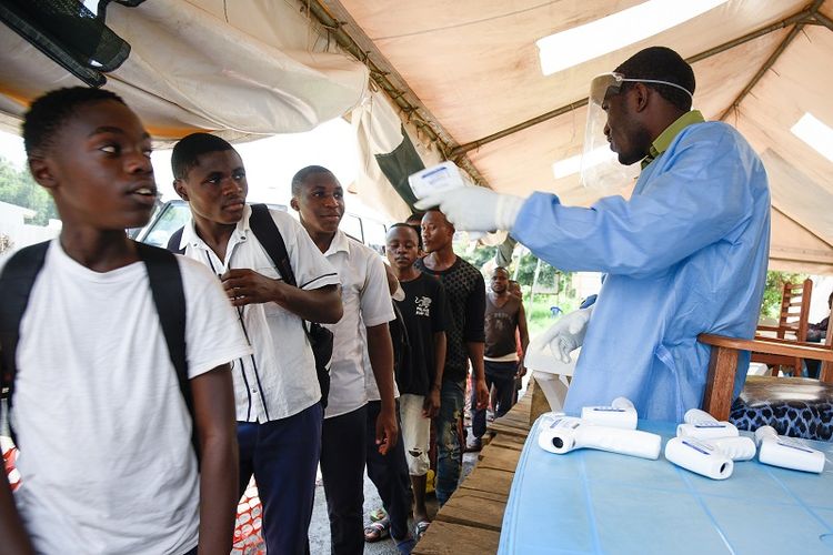 Seorang pekerja kesehatan menggunakan termometer non-kontak untuk memeriksa suhu tubuh warga Republik Demokratik Kongo (RDK) di pusat pemeriksaan Ebola di Mpondwe, Uganda, yang berbatasan dengan DRK. 