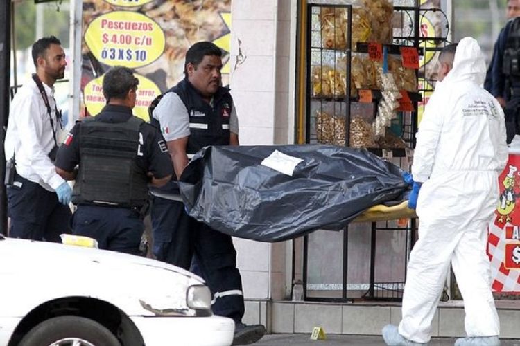 Polisi Meksiko membawa kantong jenaza berisi korban kekejaman kartel pimpinan El Mencho.