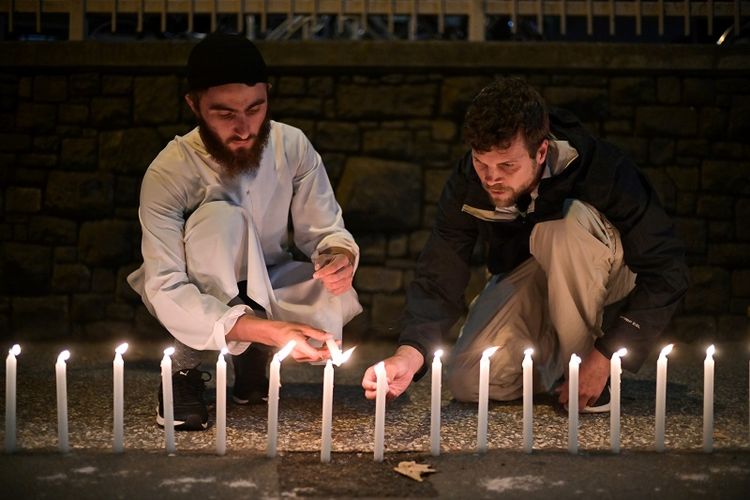 Sejumlah warga menyalakan 49 batang lilin di luar gedung rumah sakit di Christchurch, Selandia Baru, Sabtu (16/3/2019) untuk mengenang korban tewas dalam serangan teror terhadap dua masjid di kota itu. 
