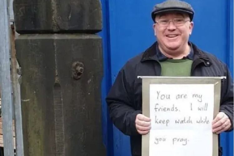 Inilah Andrew Graystone, pria yang berdiri di depan Masjid Madina Manchester, Inggris, sambil membawa papan bertuliskan Kalian Temanku, Saya Akan Berjaga Ketika Kalian Shalat ketika penembakan di Masjid Christchurh, Selandia Baru, terjadi Jumat (15/3/2019).