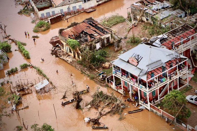 Warga terpaksa berjalan di jalanan kota Buzi, wilayah tengah Mozambik yang masih digenangi banjir usai dihantam badai tropis Idai. 