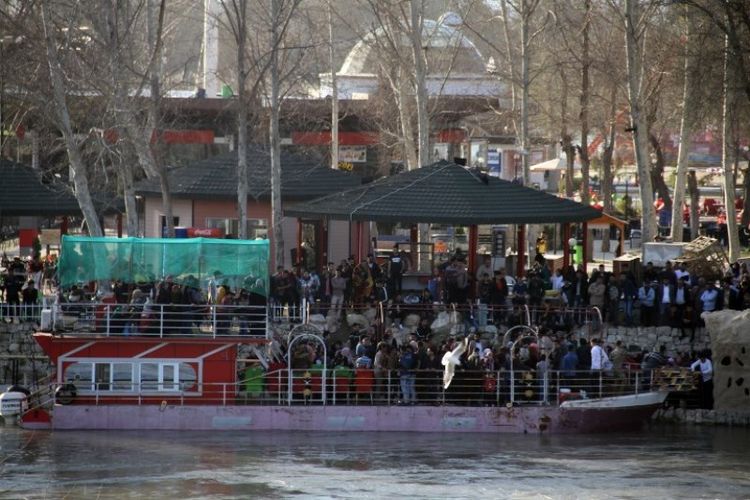 Sebuah kapal feri yang membawa sejumlah keluarga di kota Mosul, tepi sungai Tigris, Irak, pada Kamis (21/3/2019). (AFP/WALEED AL-KHALED)