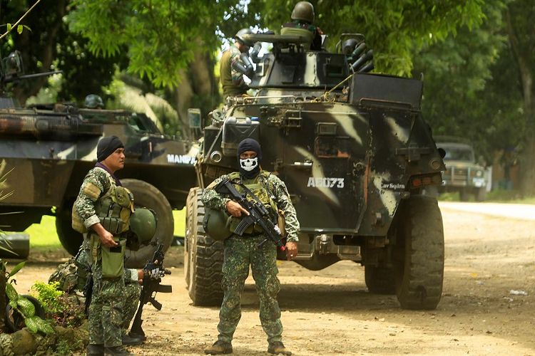 Dalam foto yang diambil pada September 2016 ini terlihat beberapa prajurit AD Filipina bersiaga di dekat kendaraan lapis baja di sebuah kamp militer di Jolo, prosvinsi Sulu, di pulau Mindanao, yang menjadi basis kelompok militan Abu Sayyaf. 