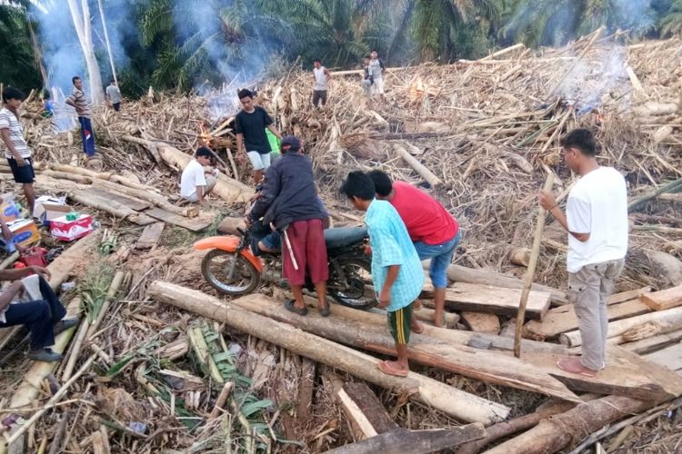 Warga membersihkan jalan karena tertutup puing-puing sisa banjir di salah satu lokasi di Kabupaten Bengkulu Tengah, Senin (29/4/2019). 