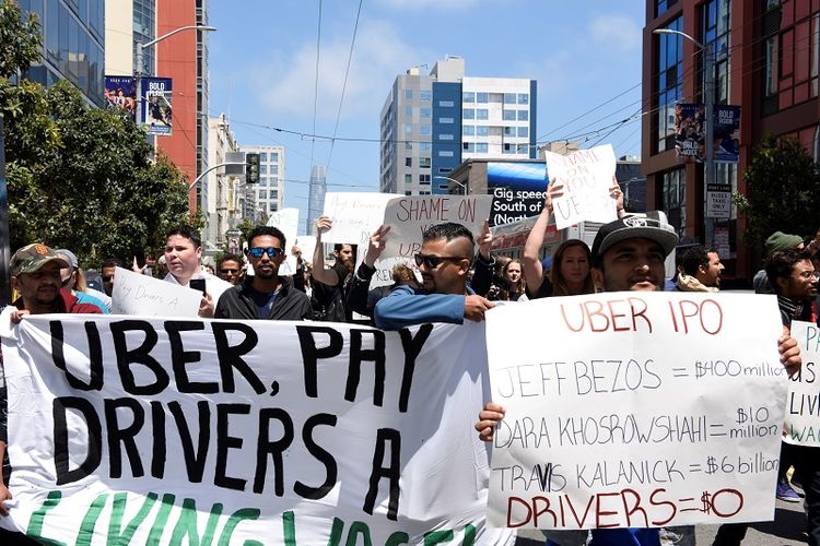 Pengemudi Uber melakukan unjuk rasa terhadap pemotongan upah 25 persen oleh perusahaan baru-baru ini. Aksi protes ini digelar di luar kantor pusat Uber di San Francisco, California, AS, Rabu (8/5/2019). (REUTERS/Kate Munsch).