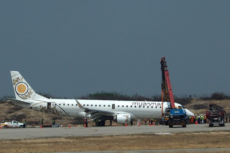 Pesawat milik Myanmar National Airlines mendarat darurat tanpa roda depan di  bandara internasional Mandalay, Myanmar, Minggu (12/5/2019). AFP)