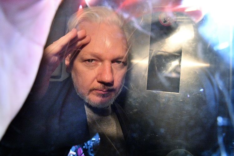 Pendiri WikiLeaks Julian Assange memberi isyarat dari jendela sebuah mobil van yang membawanya ke penjara dari Southwark Crown Court di London, Inggris, pada 1 Mei 2019. (AFP/DANIEL LEAL-OLIVAS)