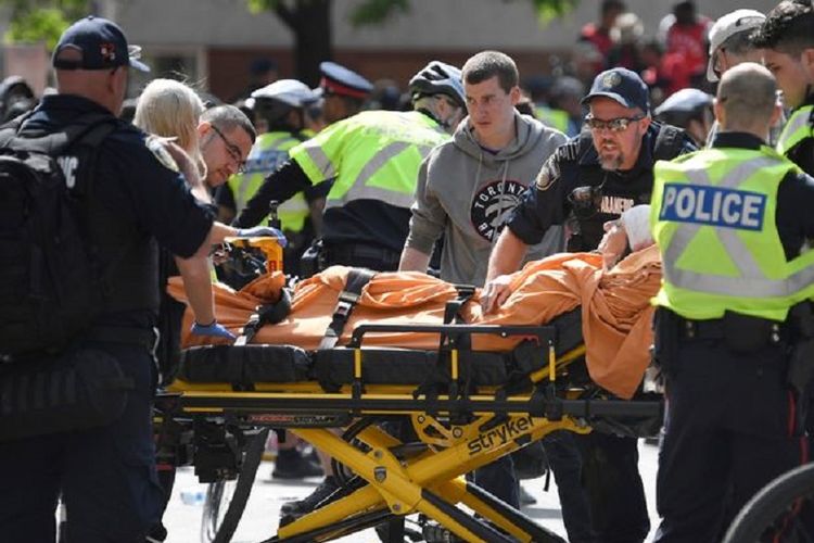 Paramedis bergegas membawa korban luka dalam insiden penembakan di Toronto, Kanada, Senin (17/6/2019). Saat insiden, warga tengah merayakan gelar juara klub basket NBA Toronto Raptors.