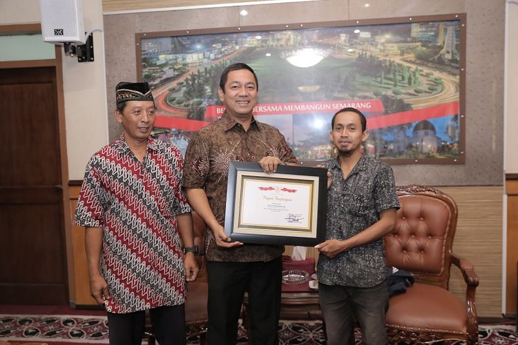 Wali Kota Semarang Hendrar Prihadi (tengah) menyerahkan penghargaan kepada Agus (sebelah kiri), warga Rejosari yang tanpa pamrih selama 2 tahun membersihkan lingkungan.