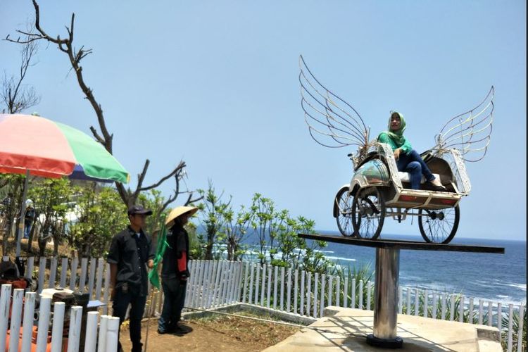 Pengunjung menaiki becak terbang di Pantai Nguluran yang menggunakan teknologi hidrolik.