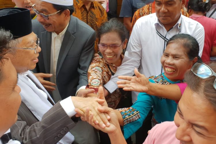 Calon wakil presiden Maruf Amin (paling kiri berpeci) menyalami ibu-ibu di sekitar kawasan Pasar Balige, Kabupaten Toba Samosir (Tobasa), Sumatera Utara, Jumat (5/10/2018). 