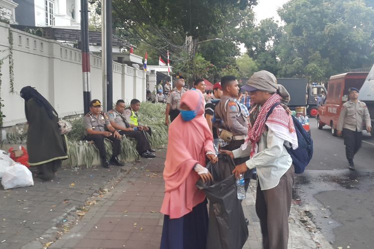 Peserta aksi unjuk rasa membersihkan sampah di lokasi aksi, sekitar Kedutaan Besar Myanmar, Jalan H Agus Salim, Jakarta Pusat, Rabu (6/9/2017) sore.