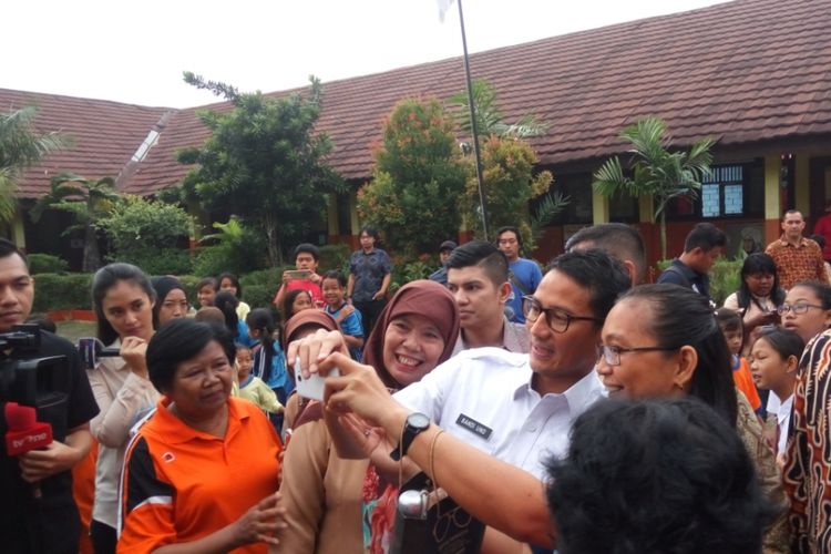 Wakil Gubernur DKI Jakarta Sandiaga Uno berselfe dengan para guru-guru SDsaat datang ke SDN 07 Pagi Cawang, Kramat Jati, Jakarta Timur, Rabu (18/10/2017) pagi.  