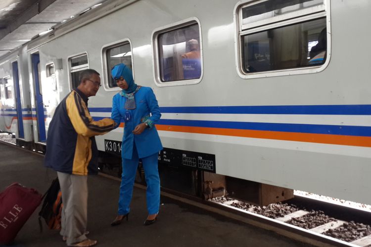 Seorang pramugari Kereta Api (KA) di Stasiun Kota Malang saat melayani penumpang, Kamis (14/12/2017)