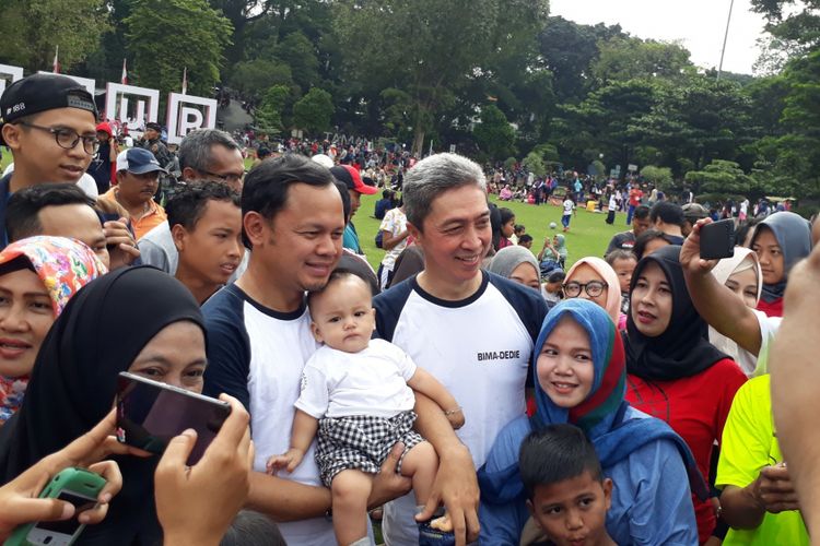 Sejumlah warga saat berfoto bersama Wali Kota Bogor Bima Arya Sugianto dan calon pasangan wakil wali kota Bogor Dedie A Rachim di Taman Sempur, Bogor, Jawa Barat, Minggu (7/1/2018).