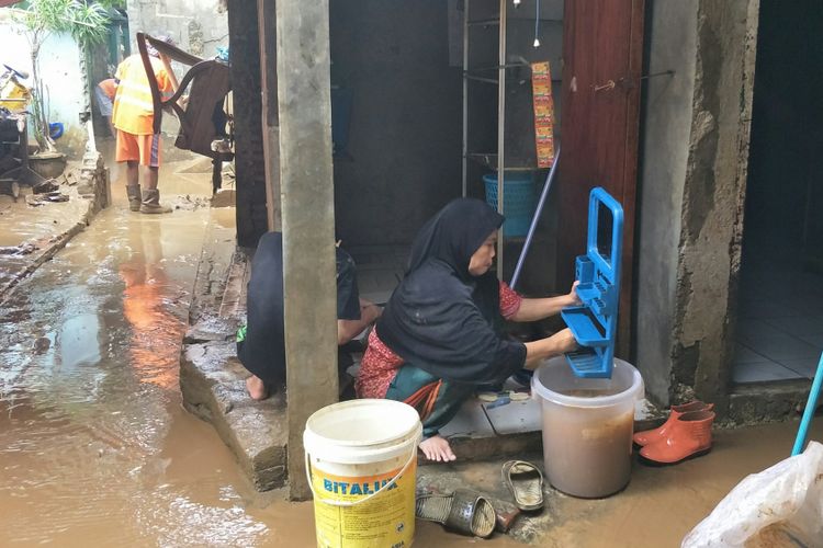Warga membersihkan peralatan rumah tangga pasca-banjir luapan Sungai Ciliwung di Kelurahan Rawajati, Jakarta Selatan, Selasa (6/2/2018)