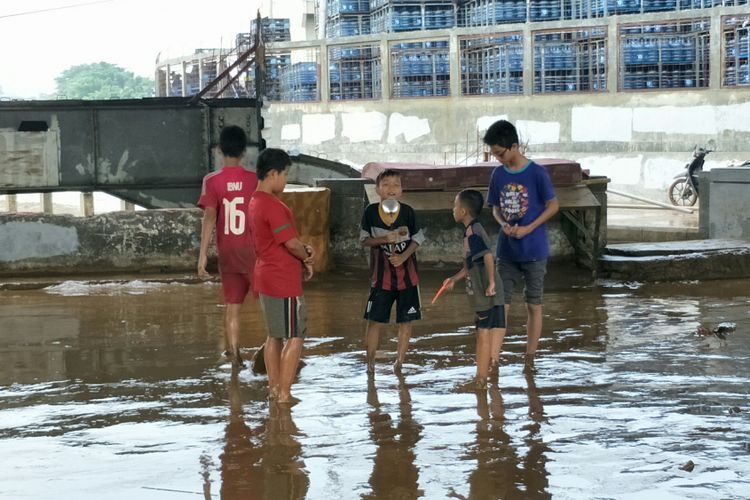 Anak-anak bermain lumpur pasca-banjir di kolong Flyover Rawajati, Jakarta Selatan, Selasa (6/2/2018).