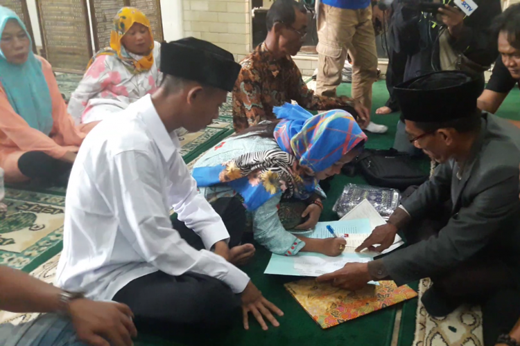 Kedua mempelai menandatangani buku nikah usah menjalani prosesi pernikahan di musala Mapolsek Penjaringan, Jakarta Utara, Rabu (21/3/2018).