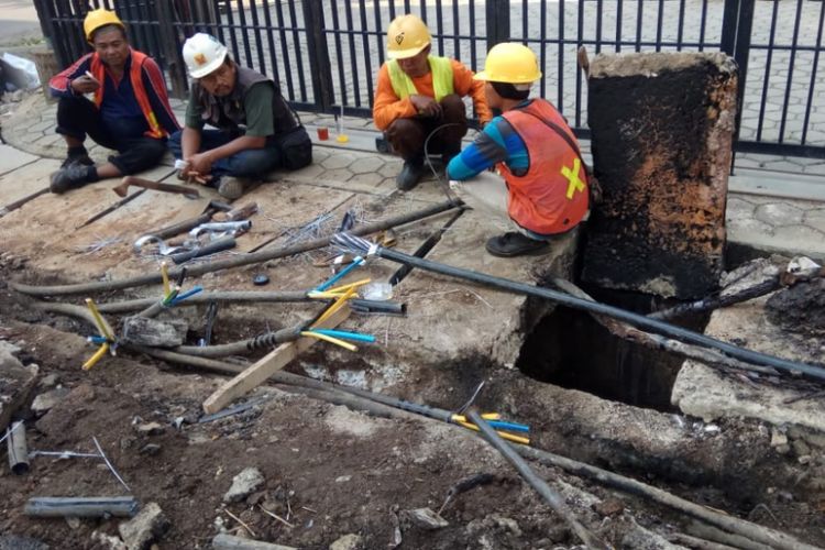 Petugas sedang melakukan perbaikan pada kabel listrik yang sempat mengeluarkan percikan api di kawasan Fatmawati,  Jakarta Selatan, Minggu (8/7/2018). (Dokumen Polres Jakarta Selatan)