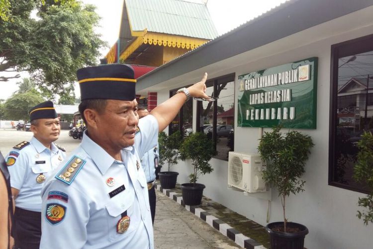 Kalapas Pekanbaru Yulius Sahruza menunjukkan bekas tembakan orang tak dikenal di gerai pelayanan publik Lapas Pekanbaru, Riau, Senin (9/7/2018).