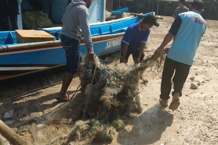 Nelayan Pantai Drini, Gunungkidul, Yogyakarta, sedang mengevakuasi jaring yang rusak akibat gelombang tinggi, Rabu (18/7/2018) malam.