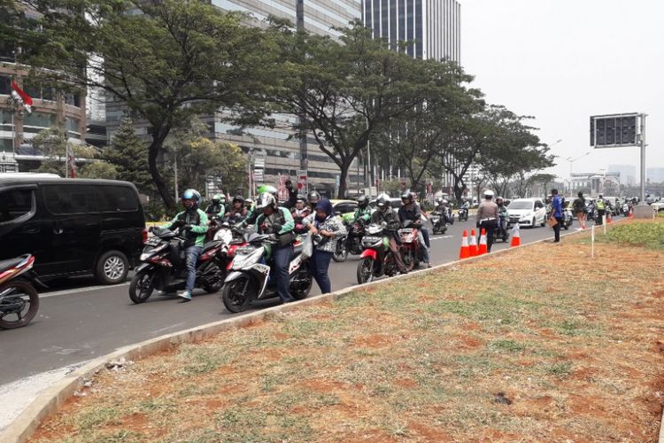Beberapa pengemudi ojek online berhenti di tepi Jalan Jenderal Sudirman depan Mal FX, Minggu (2/9/2018).