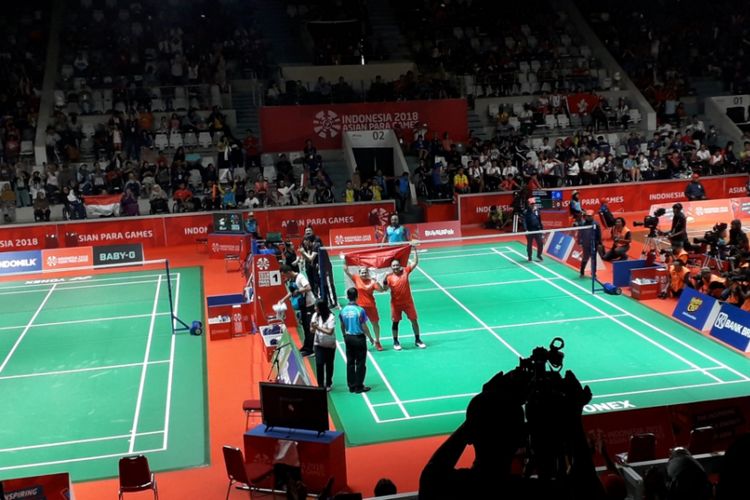 Pasangan ganda campuran para bulutangkis Indonesia, Leani Ratri Oktila dan Hary Susanto mengibarkan bendera merah putih setelah berhasil menyumbangkan emas ganda campuran nomor SL3-SU5. Raihan tersebut diperoleh setelah keduanya mengalahkan pasangan Thailand, Nipada Saensupa dan Siripong Teammarom dalam laga yang berlangsung di Istora Senayan, Jakarta, Sabtu (13/10/2018).