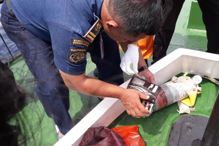 Petugas memeriksa sebuah dompet yang ditemukan dari lokasi dugaan jatuhnya pesawat Lion Air JT610 di perairan Karawang, Senin (29/10/2018).