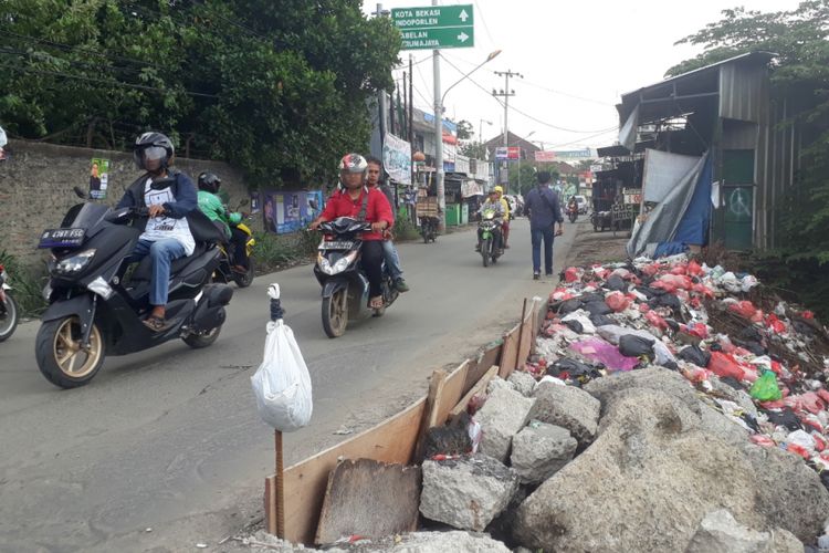 Tampak jalan Raya Karang Satria, Kabupaten Bekasi, yang rawan amblas kerap membahayakan pengendara yang melintas, Selasa (27/11/2018).