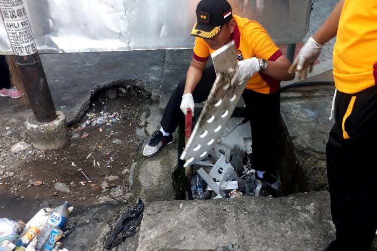 Personil polres palopo bersihkan sampah plastik yang menumpuk dan menyumbat saluran drainase di area pasar pusat niaga palopo, Jumat (22/02/2019) 