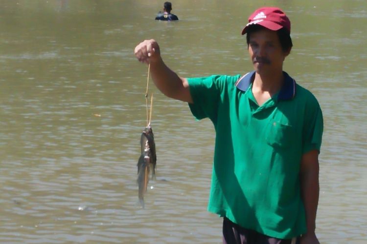 Warga menunjukkan ikan hasil tangkapan dalam Tradisi Tubo yang berlangsung di sungai Tuntang di Kecamatan‎ Kedungjati, Kabupaten Grobogan, Jateng, Selasa (24/7/2018) siang.