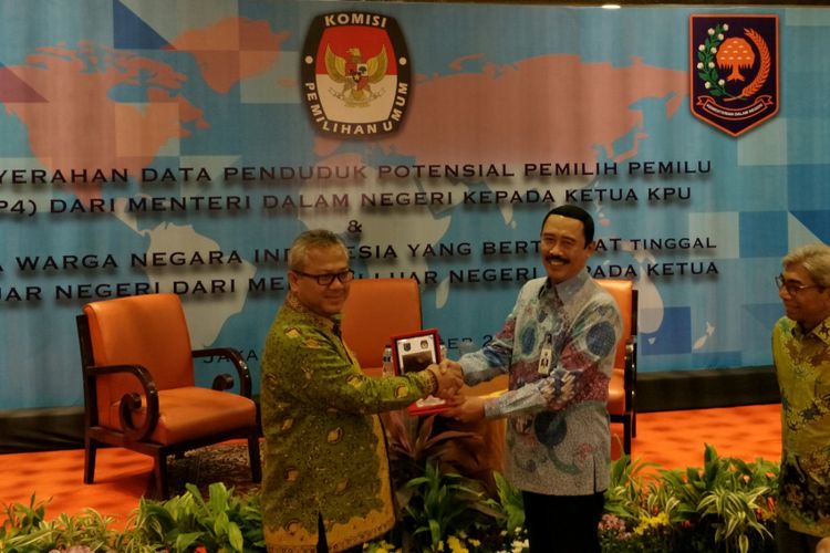 Sekretaris Jenderal Kementerian Dalam Negeri Hadi Prabowo (tengah) menyerahkan Data Penduduk Potensial Pemilih Pemilu (DP4) kepada Ketua Komisi Pemilihan Umum (KPU) Aried Budiman (kiri) untuk pemilihan legislatif (pileg) dan pemilih presiden (pilpres) 2019 mendatang di hotel Borobudur, Jakarta, Jumat (15/12/2017). 