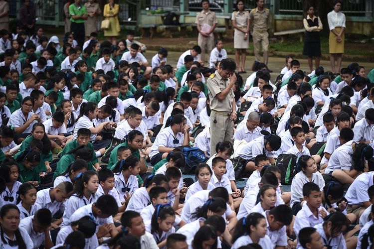 Para guru dan siswa dari sekolah Mae Sai Prasitsart di Thailand berdoa untuk keselamatan murid serta teman mereka yang terjebak di dalam goa.
