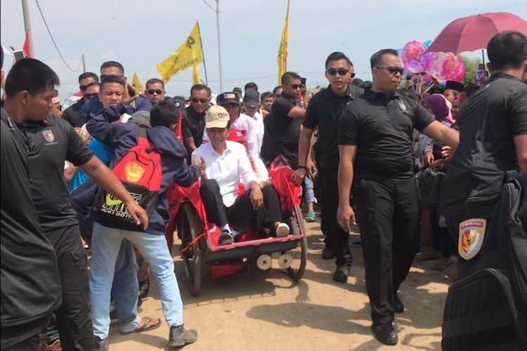 Capres petahana Joko Widodo beserta sang istri Iriana menaiki becak saat menghadiri kampanye terbuka di Pelabuhan Perikanan Gebang Mekar, Kabupaten Cirebon, Jawa Barat, Jumat (5/4/2019).