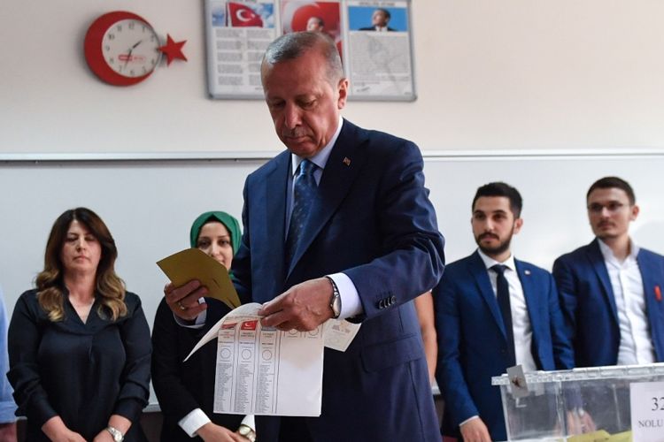 Calon petahana, sekaligus pemimpin Partai Keadilan dan Pembangunan (AKP) Turki, Recep Tayyip Erdogan bersiap memberikan suara dalam pemilu pemilihan presiden di Istanbul, Minggu (24/6/2018).