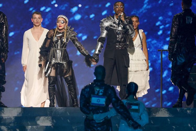 Momen ketika dua penari latar yang mengenakan kostum dengan bendera Palestina dan Israel berjalan berdampingan saat penampilan Madonna pada malam final kontes Eurovision yang digelar di Tel Aviv, Sabtu (18/5/2019) malam.