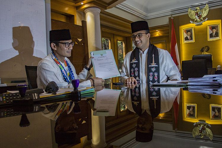 Gubernur DKI Jakarta Anies Baswedan (kanan) dan Sandiaga Uno (kiri) menunjukkan surat pengunduran diri Sandiaga sebagai Wagub DKI Jakarta di Balai Kota, Jakarta, Jumat (10/8/2018). Sandiaga Uno resmi mundur dari jabatannya sebagai Wakil Gubernur DKI Jakarta untuk menjadi bakal calon wakil presiden mendampingi bakal calon presiden Prabowo dalam Pilpres 2019.