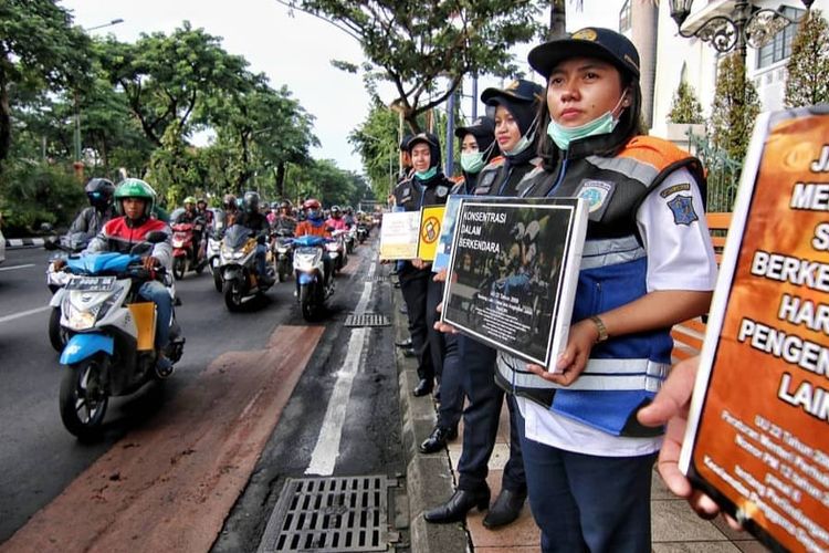 Sejumlah petugas dari Dinas Perhubungan Kota Surabaya melakukan sosialisasi larangan merokok saat berkendara di depan Graha Wismilak, Surabaya, Selasa (9/4/2019).