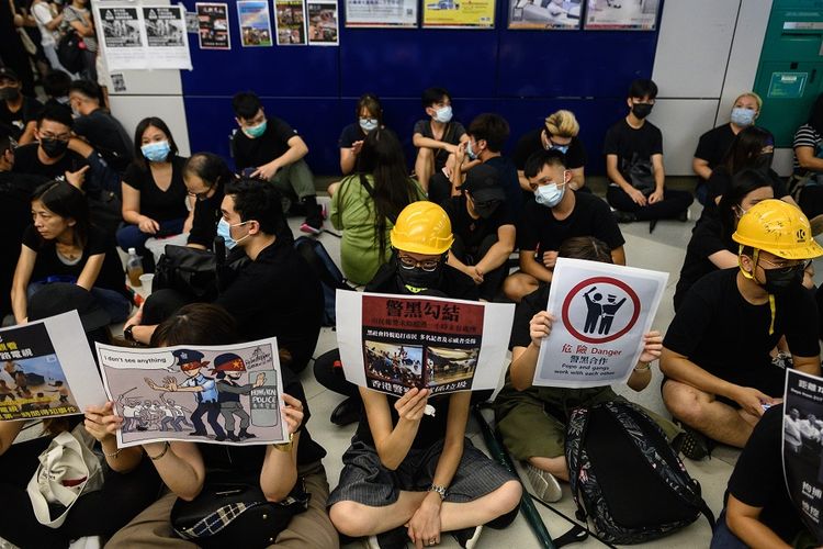 Warga Hong Kong mengenakan masker dan kaus hitam melakukan aksi menduduki stasiun MRT di Yuen Long, tempat terjadinya penyerangan oleh kelompok pria tak dikenal, sebulan sebelumnya.