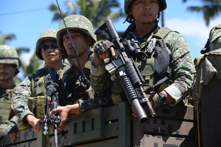 Pasukan Filipina menaiki truk dalam perjalanan ke garis depan di pinggiran Marawi, Mindanao pada tanggal 28 Juni 2017.  