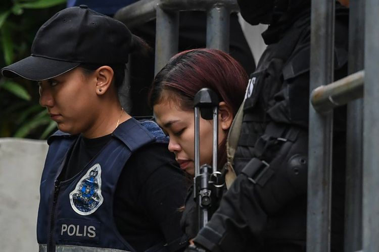 Foto arsip yang diambil pada tanggal 1 Maret 2017 ini menunjukkan warga negara Indonesia Siti Aisyah (25), dikawal  polisi setelah muncul di pengadilan dengan seorang warga Vietnam Doan Thi Huong (29), di Pengadilan di Sepang. Keduanya dituduh terlibat dalam pembunuhan Kim Jong Nam, saudara tiri pemimpin Korea Utara Kim Jong-Un. 