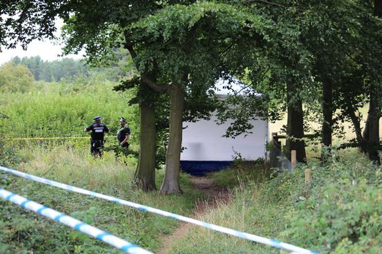 Tenda putih di pasang di lokasi penemuan mayat di kawasan hutan dengan jalan setapak yang biasa digunakan warga, di Desa Harling di timur Norfolk, Inggris.  