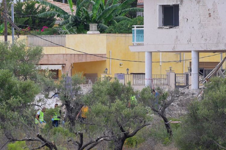 Para penyeldik Spanyol, Minggu (20/8/2017) memeriksa puing-puing sebuah rumah di kota Alcanar, di mana para tersangka serangan kembar mempersiapkan bom. Di tempat inilah polisi menemukan lebih dari 120 tabung gas.