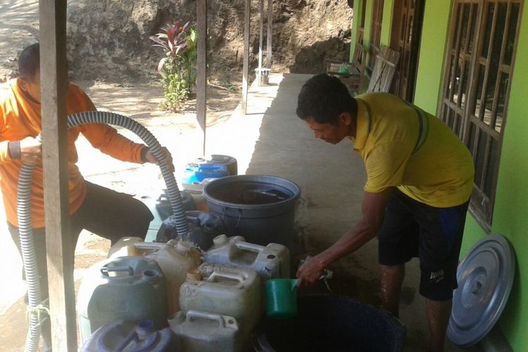Petugas Badan Penanggulangan Bencana Daerah (BPBD) Kabupaten Ponorogo mengisi air bersih pada jeriken milik warga Desa Duri, Kecamatan Slahung yang mengalami krisis air bersih satu bulan terakhir, Rabu (22/8/2017).