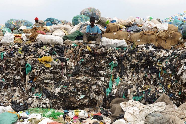 Seorang pria duduk di atas tumpukan sampah di pembuangan kota Ngong, Kenya