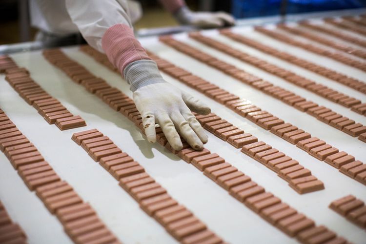 Dalam gambar yang diambil pada tanggal 24 Agustus 2017, seorang pekerja Jepang memeriksa batang KitKat rasa stroberi di jalur produksi di pabrik KitKat di Inashiki, prefektur Ibaraki, timur laut Tokyo. 