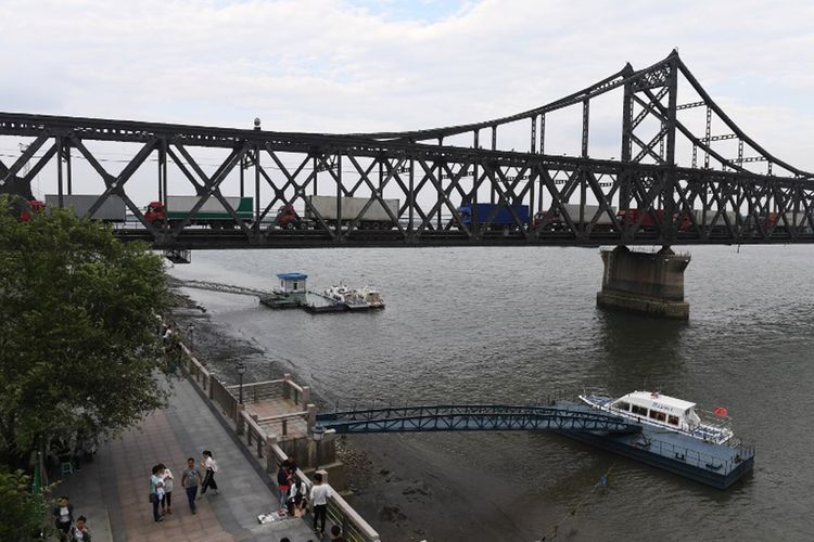 Gambar ini diambil pada tanggal 5 September 2017, yang menunjukkan truk menunggu di Friendship Bridge sebelum melewati pemeriksaan pabean di Dandong, di Provinsi Liaoning, China timur laut, setelah kembali dari Kota Sinuiju di Korea Utara.

Cabang-cabang bank terbesar China telah membekukan transaksi keuangan untuk warga Korea Utara, sebuah pertanda bahwa Beijing memperketat sekrup sekutunya atas kegiatan nuklirnya.  