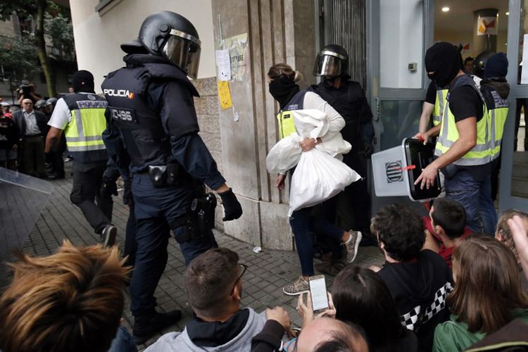 Polisi Spanyol menyita kotak suara di sebuah tempat pemungutan suara di Barcelona, pada tanggal 1 Oktober 2017, di hari referendum untuk kemerdekaan Catalonia yang ditentang oleh Pemerintah Madrid.