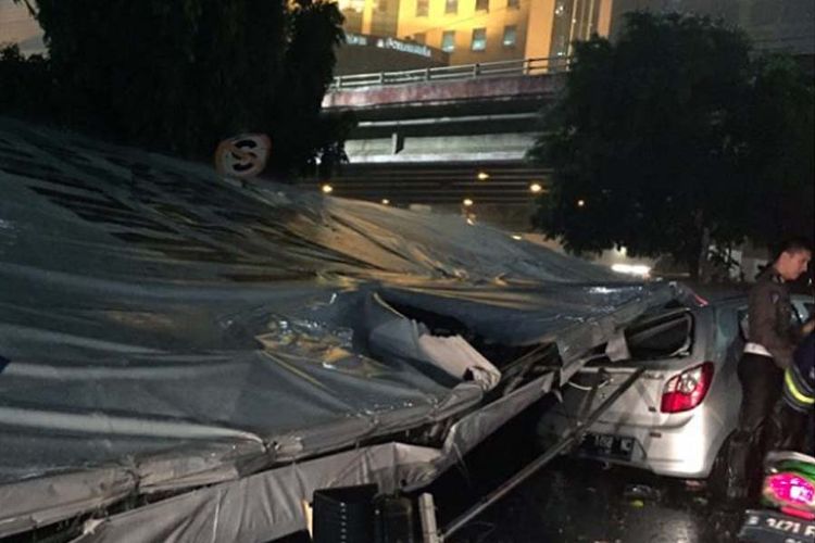 Mobil tertiban billboard di Jakarta.