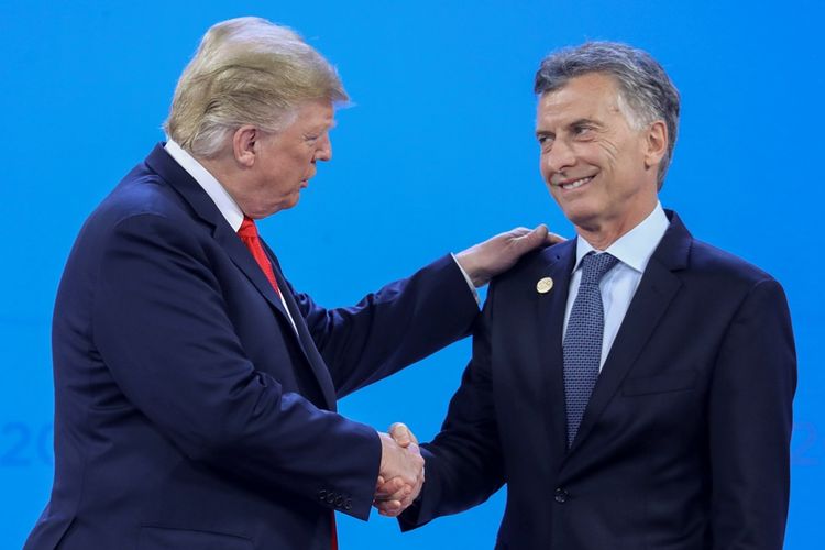 Presiden AS Donald Trump bersalaman dengan Presiden Argentina Mauricio Macri di atas panggung KTT G20 di Buenos Aires, Jumat (30/12/2018).